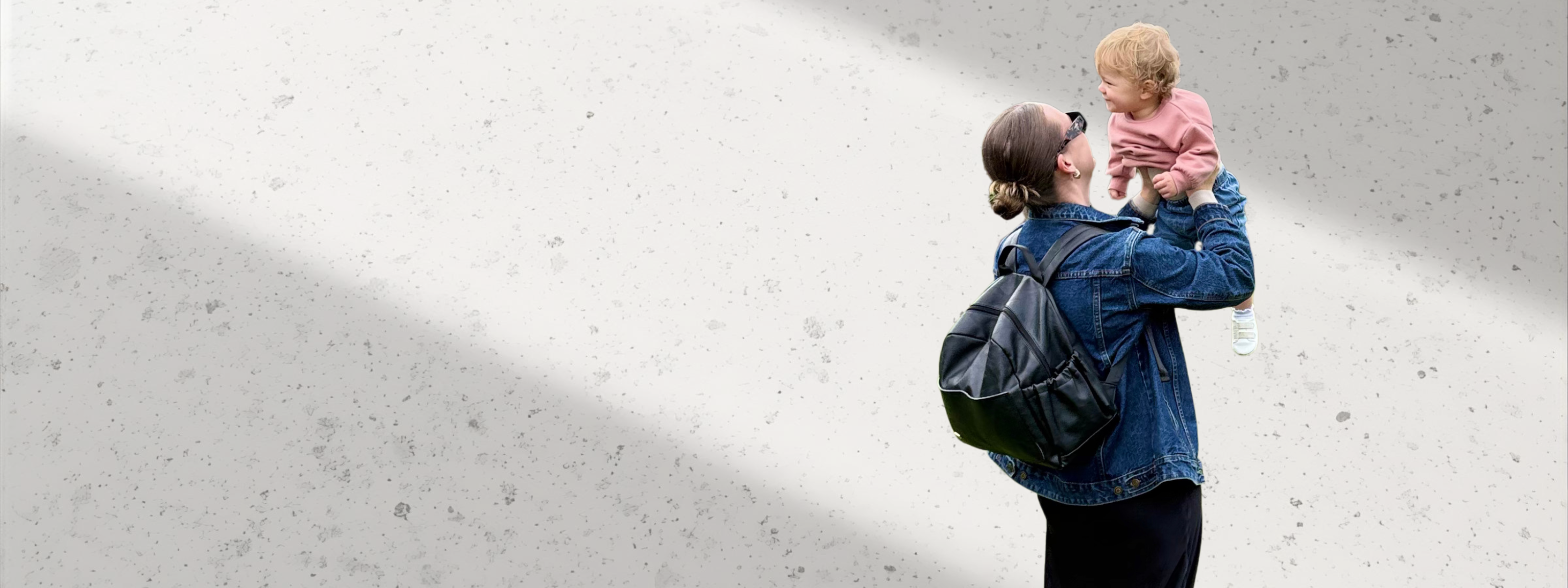 Remmii Mum Holding Child Up While Wearing Emerson Nappy Backpack
