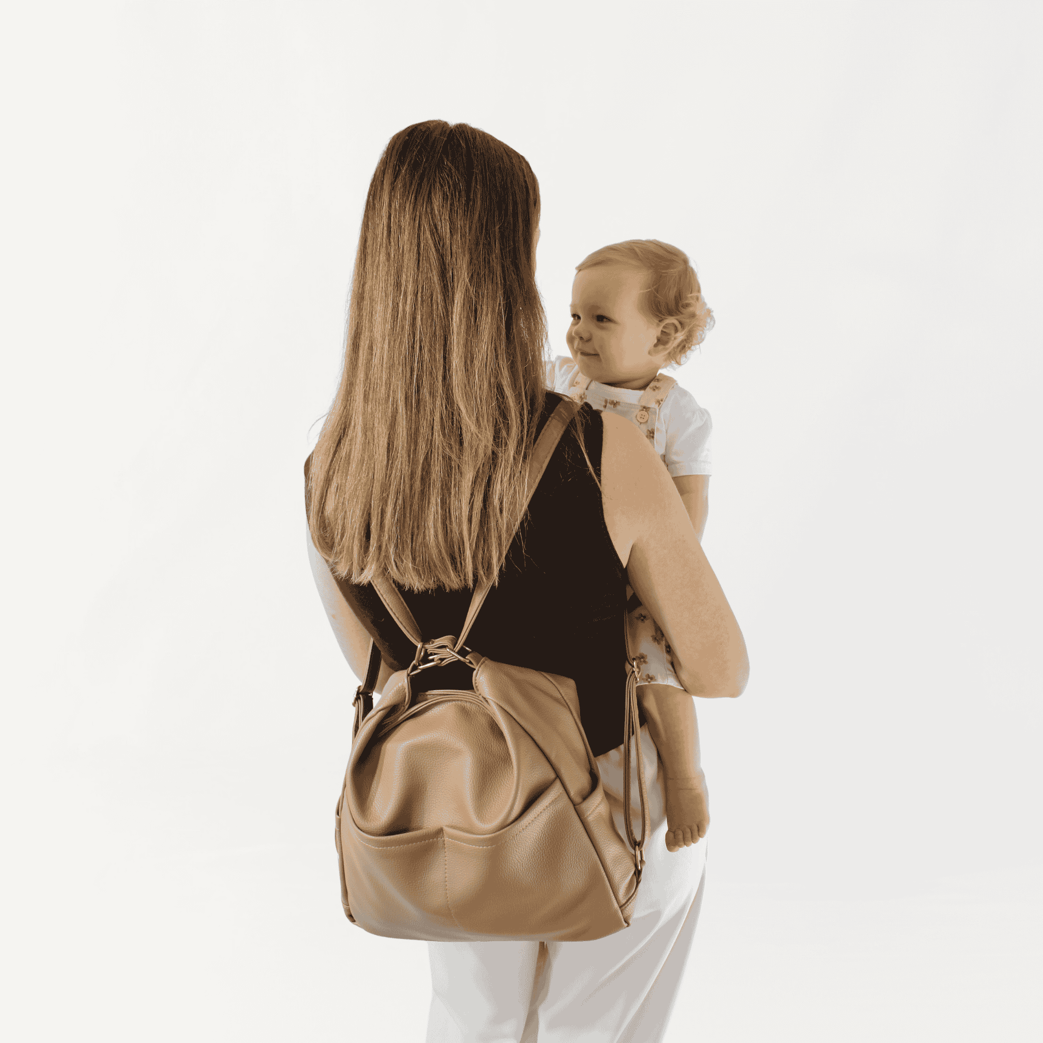 Remmii Noah Baby Tote in Tan, Being Worn As Backpack with Baby
