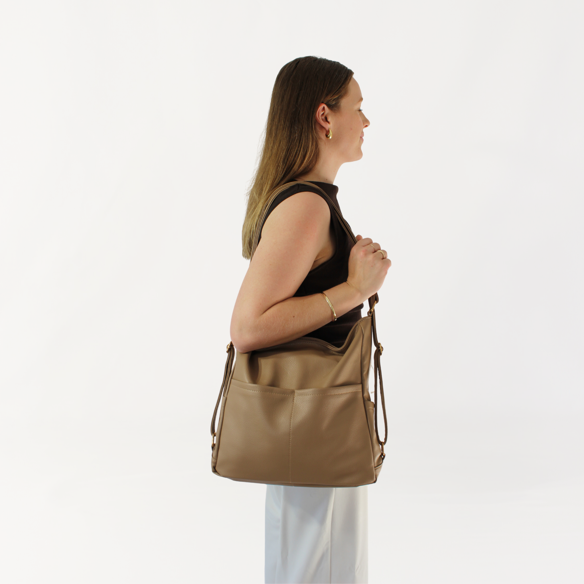 Remmii Noah Baby Tote in Tan, Being Worn Over One Shoulder Holding Strap