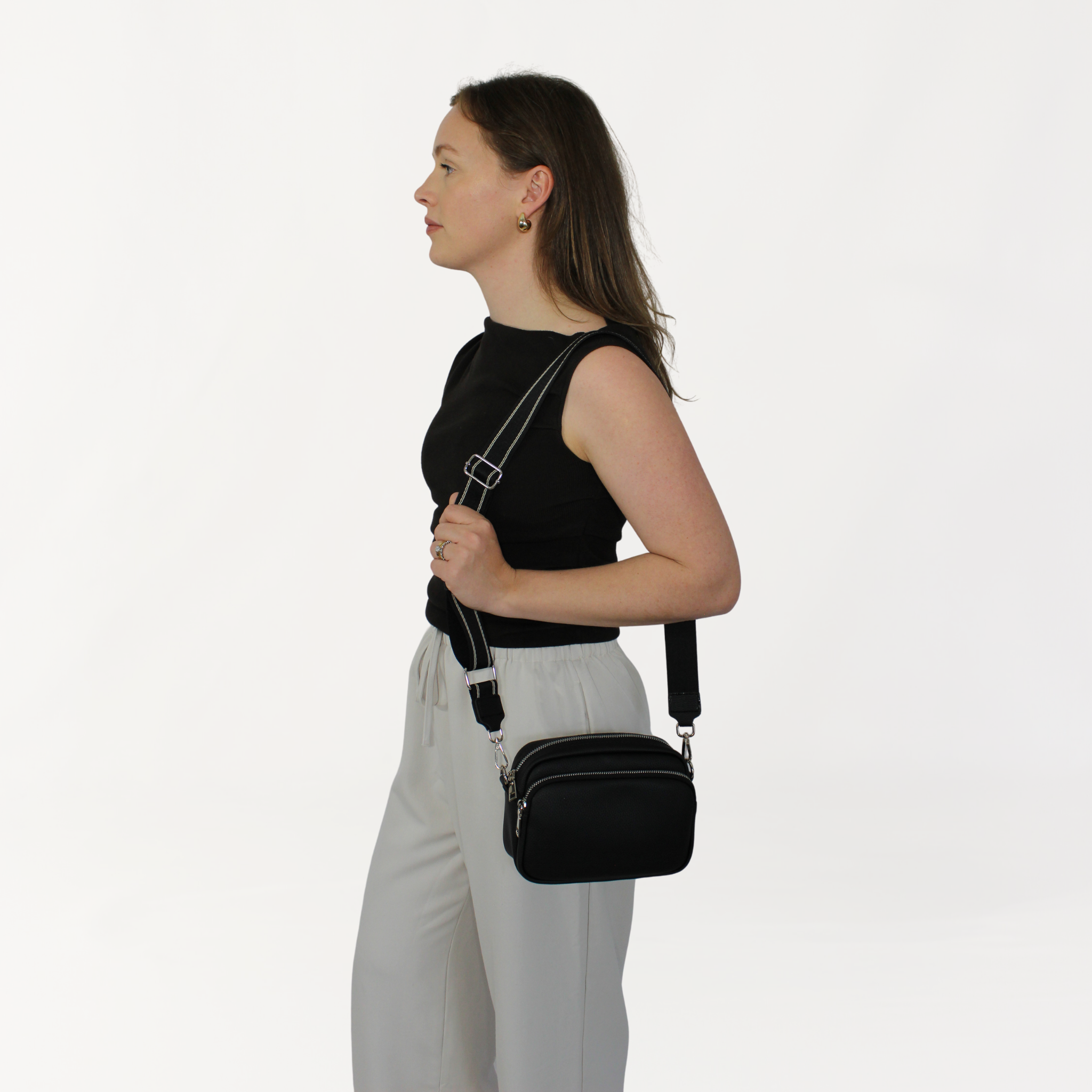 Remmii Riley Crossbody Baby Bag in Black, Being Worn Over One Shoulder