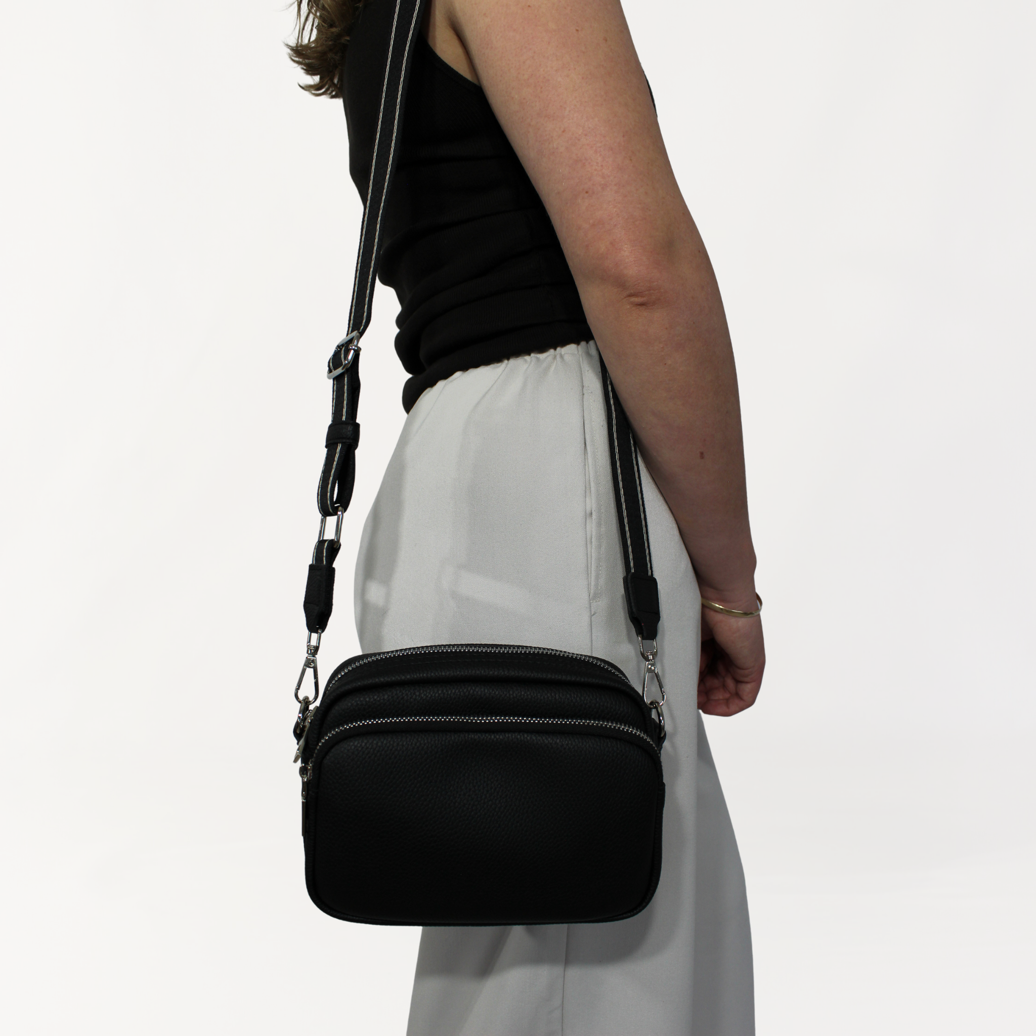 Remmii Riley Crossbody Baby Bag in Black, Being Worn Over One Shoulder Close Up